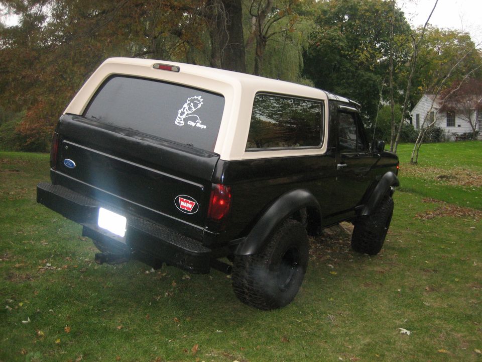 Black and tan Ford Bronco from rear-three-quarter view