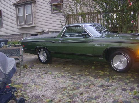 1970 Ford Ranchero - A green 1970 Ford Ranchero is parked in front of a house, with a stroller visible in the foreground.