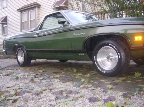 1970 Ford Ranchero - Side profile of a green 1970 Ford Ranchero with chrome trim and aftermarket wheels.