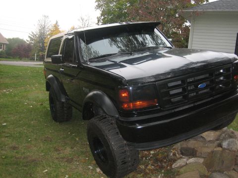 1995 Ford Bronco - This 1995 Ford Bronco features a visor and large tires, giving it a distinctive look.