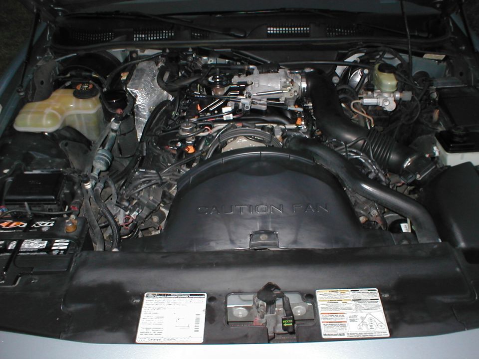 1997 Ford Crown Victoria engine bay with V8 engine, air intake, and coolant reservoir