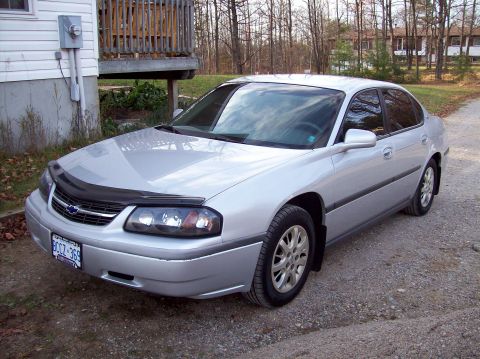 2001 Chevrolet Impala - This silver sedan has a black bug deflector on the hood and a visible license plate.