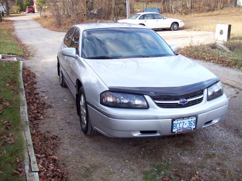 2001 Chevrolet Impala - A silver sedan is parked on a gravel driveway with a white car in the background.