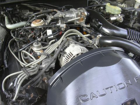 1997 Ford Crown Victoria - Close-up of an engine bay, showing various components and a 'CAUTION' warning.