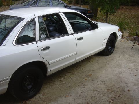 1997 Ford Crown Victoria - Side view of a white 1997 Ford Crown Victoria, parked outdoors.