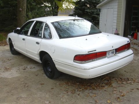1997 Ford Crown Victoria - White 1997 Ford Crown Victoria parked outside a garage on a dirt driveway.