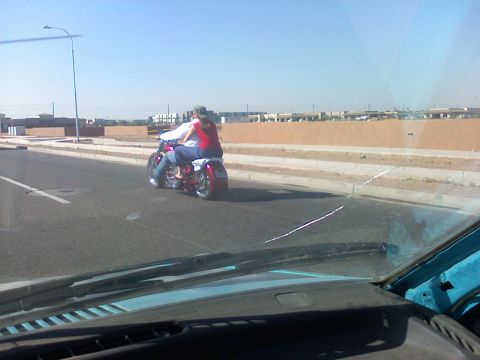 2007 Kawasaki Ninja - Two people ride a motorcycle on a sunny day, viewed from inside another vehicle.