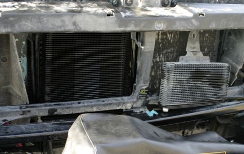 1994 Ford Bronco - Close-up view of the vehicle's cooling system components, including the radiator and an auxiliary cooler.