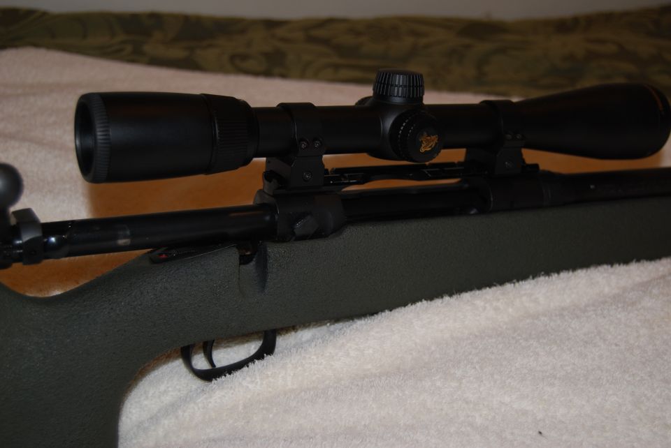 Rifle with a black scope mounted on top