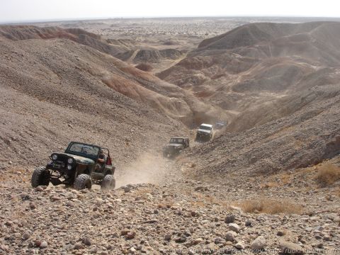 1994 Ford Bronco - Multiple off-road vehicles navigate a challenging, dusty canyon trail.