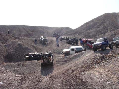 1994 Ford Bronco - Multiple off-road vehicles are seen traversing a challenging, arid landscape with steep inclines and rough terrain.