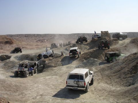 1994 Ford Bronco - Multiple off-road vehicles, including a 1994 Ford Bronco, traverse a challenging desert landscape.