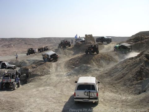 1994 Ford Bronco - Multiple off-road vehicles navigate a challenging, dusty terrain under a clear sky.