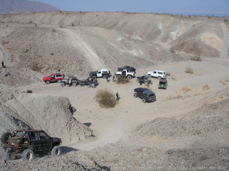 Off-road vehicles gathered in a desert canyon