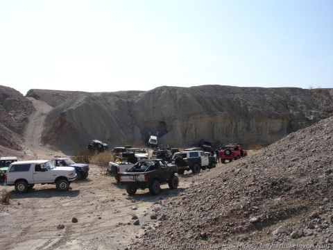1994 Ford Bronco - Multiple off-road vehicles are gathered in a dusty, rocky quarry under a clear sky.