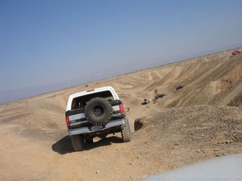 1994 Ford Bronco - Ford Bronco navigates a desert trail with multiple vehicles in the background.