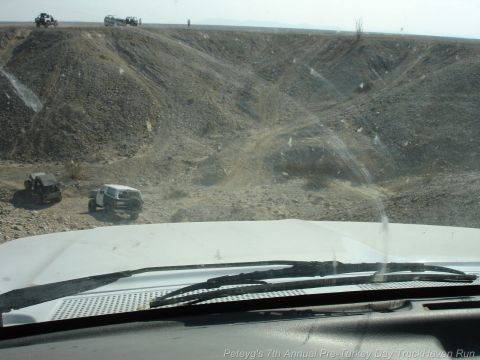 1994 Ford Bronco - Multiple off-road vehicles navigate a dusty, rocky terrain under a bright sky.
