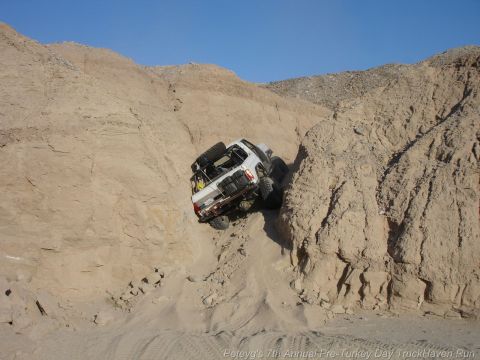 1994 Ford Bronco - 1994 Ford Bronco navigates a challenging off-road course on a sunny day.