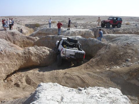 1994 Ford Bronco - Off-road vehicles traverse a challenging desert terrain with onlookers observing the action.