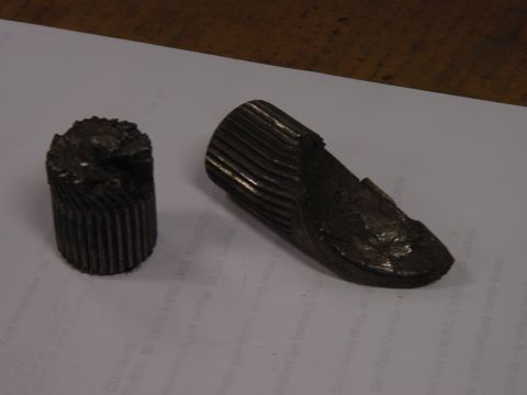 1979 Ford Bronco - Two damaged metal components, possibly from a drivetrain or machinery, are shown in close-up.