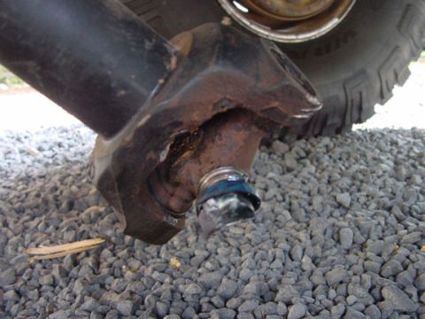 1979 Ford Bronco - A close-up view of a damaged and rusted vehicle suspension component, showing signs of wear and tear.