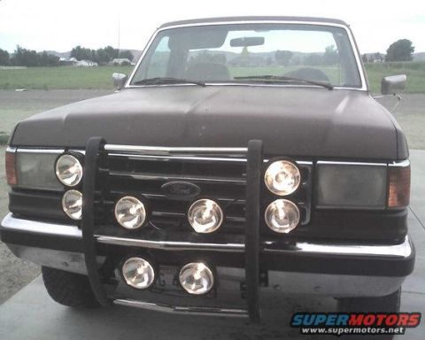 1994 Ford Bronco - Frontal view of a Ford Bronco, a brush guard with auxiliary lights. The body style suggests a mid-1990s model.
