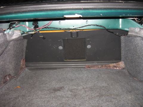 1992 Ford Crown Victoria - Interior view of a car's trunk, revealing carpeting, exposed wiring, and a speaker enclosure.