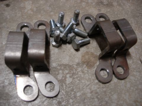1985 Toyota Hilux - A collection of assorted metal brackets and hex bolts are laid out on a textured concrete floor.