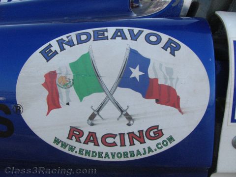 1990 Ford Bronco - Close-up of an oval Endeavor Racing decal showing crossed swords between Mexican and Texas flags with the URL endeavorbaja.com.
