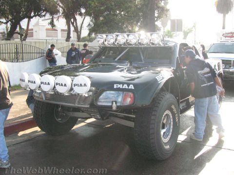 1990 Ford Bronco - Front view of a black off-road trophy truck fitted with a roof light bar and multiple round PIAA driving lights on the bumper.