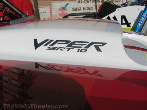 1990 Ford Bronco - Close-up of a carbon-fiber-style Viper SRT10 logo on the white and red rear bodywork of an off-road vehicle.
