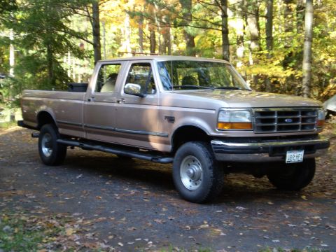 1979 Ford Bronco - This Ford F-Series truck, likely from the early to mid-1990s, is shown from a three-quarter front angle in a wooded area.