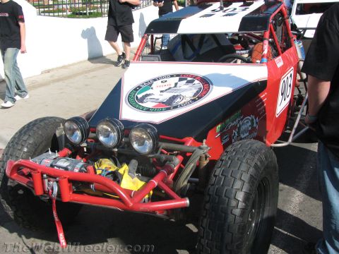1990 Ford Bronco - red, white and blue single-seat off-road race buggy, number 903, with a front winch and three auxiliary lights parked on pavement.