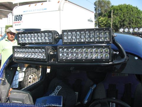 1990 Ford Bronco - Four rectangular LED light bars are mounted in a cluster on the front roll cage of an off-road vehicle, with a man nearby.