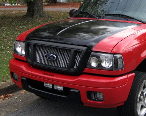 2004 Ford Ranger - The front end of a red Ford Ranger pickup truck is shown, a custom black hood and grille with the Ford emblem.