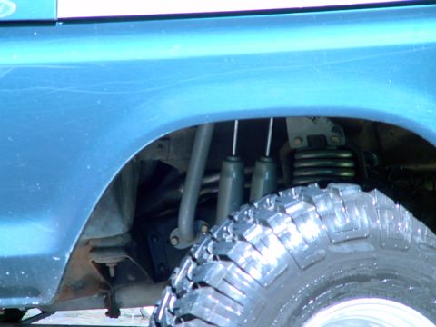 1979 Ford Bronco - The rear suspension and tire of a vehicle are visible in this close-up shot.
