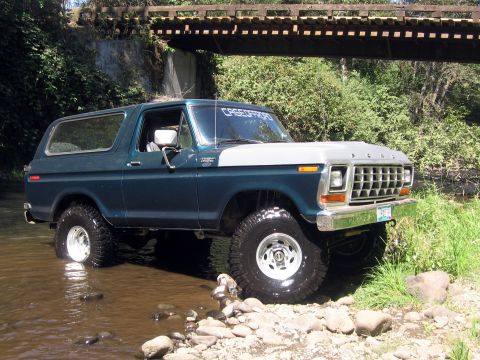 1979 Ford Bronco - This 1979 Ford Bronco navigates a rocky stream bed under a wooden bridge.