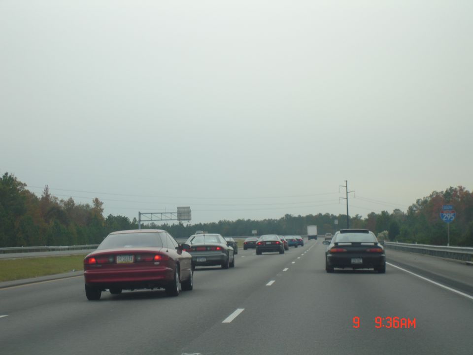 Red 1994 Ford Probe driving on highway, other cars in traffic