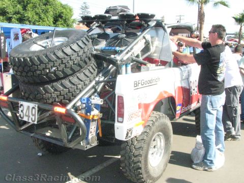 1990 Ford Bronco - Rear view of a white off-road race truck numbered 349 with twin spare tires mounted on the back and BFGoodrich graphics.