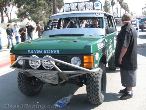 1990 Ford Bronco - Front view of a green Range Rover off-road racer numbered 304 with Hella driving lights and a tubular front bumper.