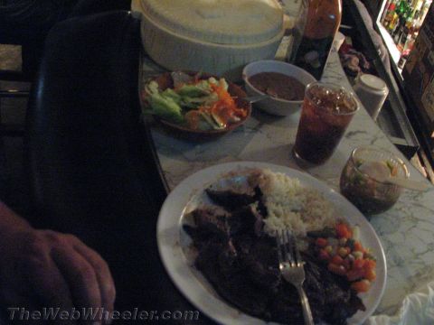 1990 Ford Bronco - meal of grilled meat with rice and mixed vegetables on a plate, with a side salad, soup and an iced drink on a marble table.