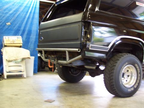 1983 Ford Bronco - This black Ford Bronco features a custom rear bumper and aftermarket wheels, indicating a modified exterior.