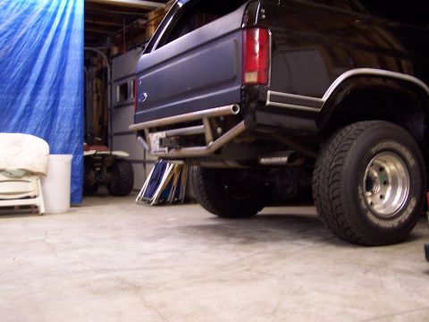 1983 Ford Bronco - The rear of a Ford Bronco is shown in a garage, a custom bumper and an ATV in the background.