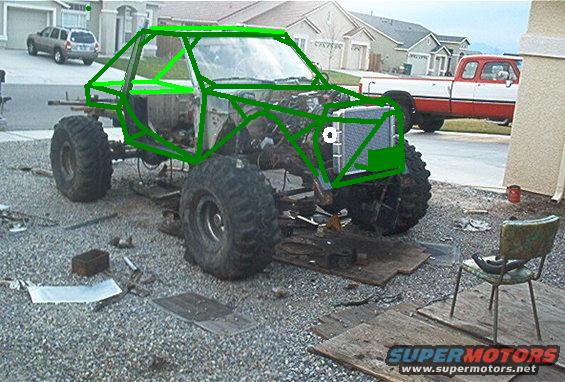 Bare truck chassis on big mud tires with green digital tube-cage design drawn over it in a driveway