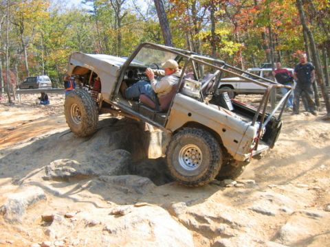 1978 Ford Bronco - A heavily modified 1978 Ford Bronco navigates a rocky trail with a driver and passenger.