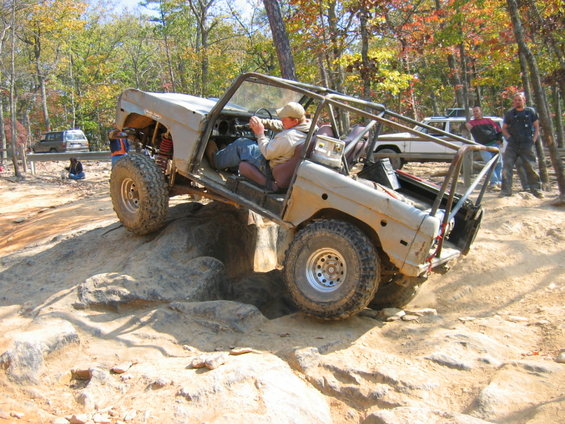Gray 1978 Ford Bronco modified for off-roading, climbing over rocks