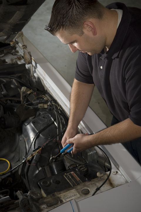 1985 Ford LTD Crown Victoria - Mechanic works on the engine wiring of a 1985 Ford Crown Victoria LTD.