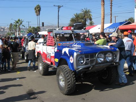 1994 Ford Bronco - This modified off-road truck, likely a 1969 Ford Bronco, is prepared for racing with its distinctive livery and safety features.