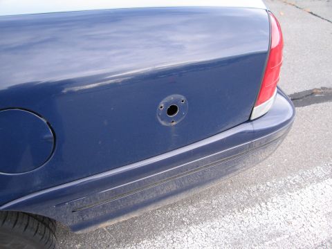1991 Ford LTD Crown Victoria - The rear quarter panel of a blue 1991 Ford Crown Victoria LTD shows the fuel door and a missing antenna mount.