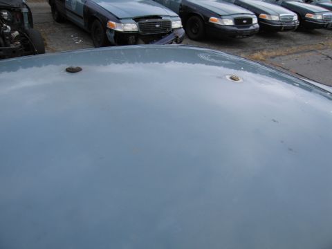 1991 Ford LTD Crown Victoria - The hood of a light blue vehicle with two circular mounts is shown, with a 1991 Ford Crown Victoria LTD visible in the background.